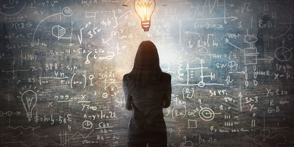 Young woman looking on the black board with mathematical formula