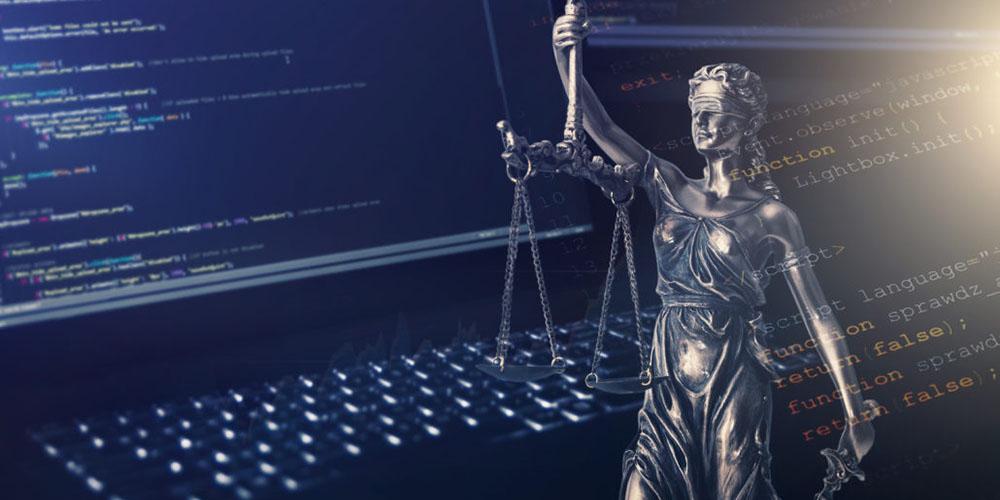 Justice statue with code on monitor device in background
